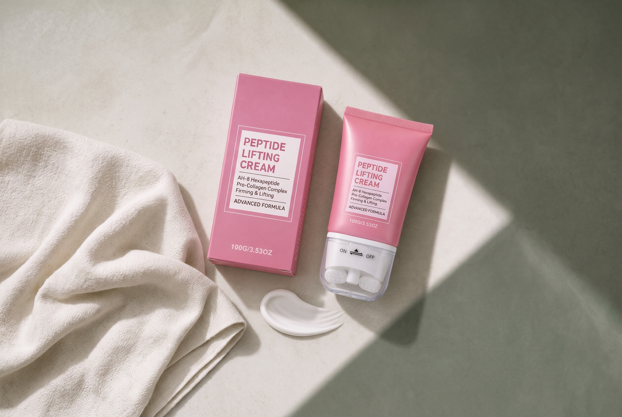 The tube, carton and a swatch of cream laid on linen, twin roller heads facing up